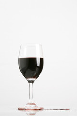 Red wine in wineglass isolated on white background ..
