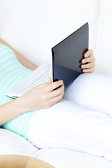 Close-up of a woman using a laptop lying on a sofa