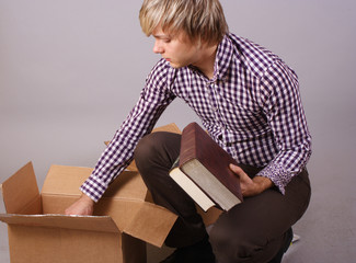 young man moving and packing things and books