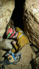 Caver passing the narrowness of the cave.