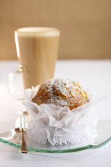 festive almond muffin and coffee latte on background