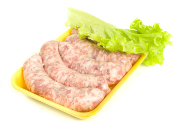 Uncooked Sausages and salad leaf