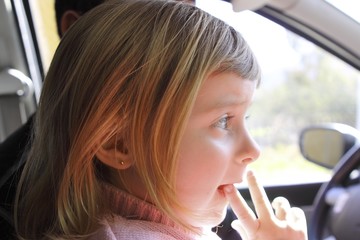 little girl blond profile in car interior portrait