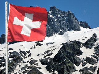 Swiss flag against snowy Alps
