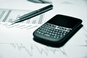 Pen and cell phone on a market report