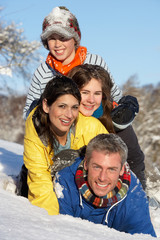 Fototapeta na wymiar Young Family Having Fun In Snowy Landscape
