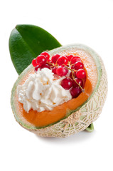 red currant over whipped cream on open melon