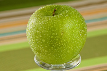 Green apple covered with water droplets