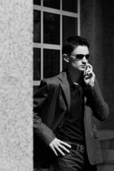 Businessman in sunglasses talks on his mobile phone (photo in mo