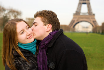 Happy couple in love kissing near the Eiffel Tower in Paris