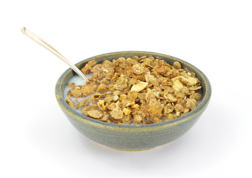 Banana and nut granola cereal with milk and spoon