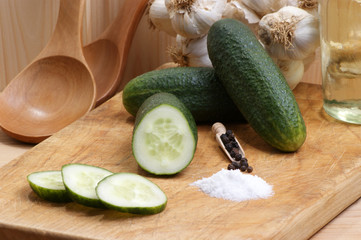 Gurken, Salz und Pfeffer auf einem Holzbrett