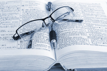 dictionary & pen with glasses