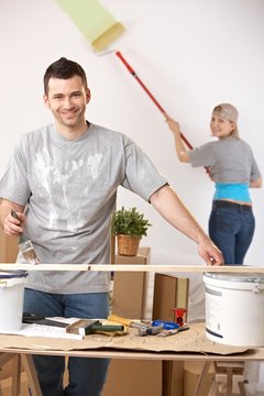 Cheerful couple painting their home