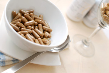 Bowl of medical capsules and beverage