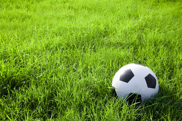 football or soccer ball on the green grass field