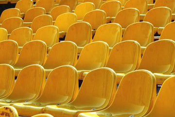Fototapeta na wymiar Empty rows of yellow plastic chairs