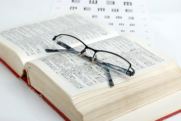 glasses, dicitonary and eye chart