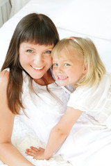 Mother and daughter in bed. Shallow DoF. Focus on mother.