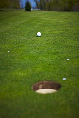 Single golf ball beside the hole on the golf course