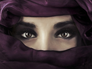 Een jonge vrouw uit het Midden-Oosten die een paarse hoofdbedekking draagt.