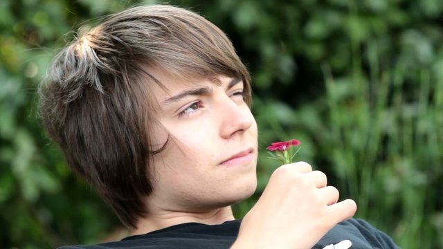 adolescent jouant avec une petite fleur