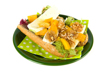 Bread roll with French cheese on green plate