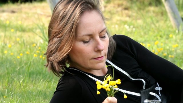 femme composant son bouquet de boutons d'or