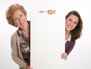 Woman and daughter holding blank board