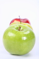 Three apples (green, yellow,red) in a raw on white background