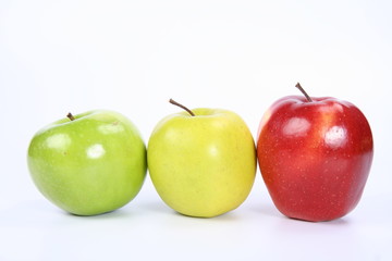 Three apples (green, yellow,red) in a raw on white background