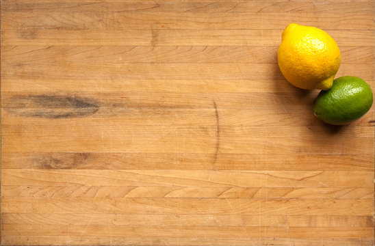 Fototapeta Lemon and lime on a wooden cutting board
