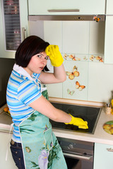 Smiling woman cleaning  cooker