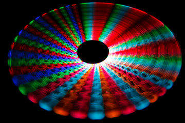 Colorful glowing trail rotating LED, in form of disc on black