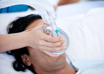Doctor who give an oxygen mask to the patient - Powered by Adobe