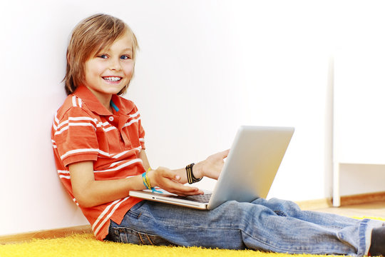 lachenender hübscher Junge mit laptop