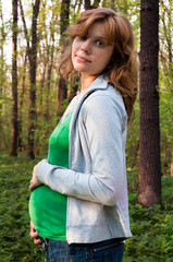 young pregnant woman holding her hands on her  tummy