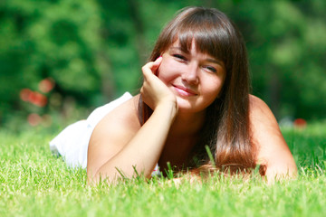 Naklejka na ściany i meble happy young girl relaxing in green grass