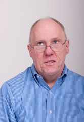 Obraz premium Older Balding Man in Blue Shirt Looking Up and to Right