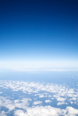 Fototapeta na wymiar blue sky above light clouds, view from a plane