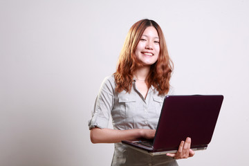 Laughing woman using a laptop  against a white background .