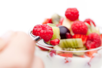 Hand mit Löffel und Obst