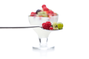 Löffel gerade vor Yoghurt mit Obst