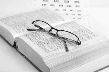glasses, dicitonary and eye chart