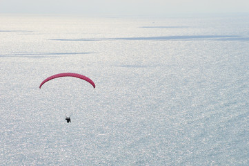 paraglider flying over the sea