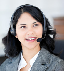 Smiling businesswoman wearing a headset to talk with customer