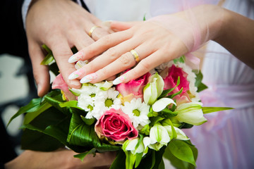 Obraz na płótnie Canvas hands of newly married with wedding bouquet