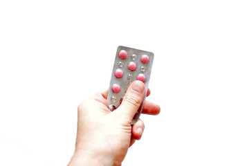 hand holding a stack of pills, isolated