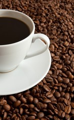 Cup of coffee on coffee beans with shallow depth of field