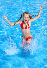 Girl  splashing in swimming pool.